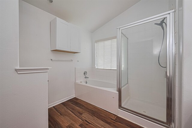 19826 Imperial Stone Dr, Houston, TX 77073 - bathroom with wood finished floors, a shower stall, a bath, lofted ceiling, and baseboards
