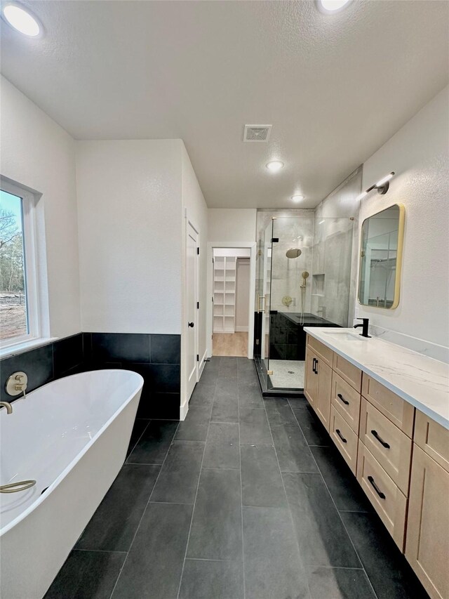1031 Denson Allen Rd, Coldspring, TX 77331 - bathroom with a shower stall, vanity, a soaking tub, a spacious closet, and tile patterned floors