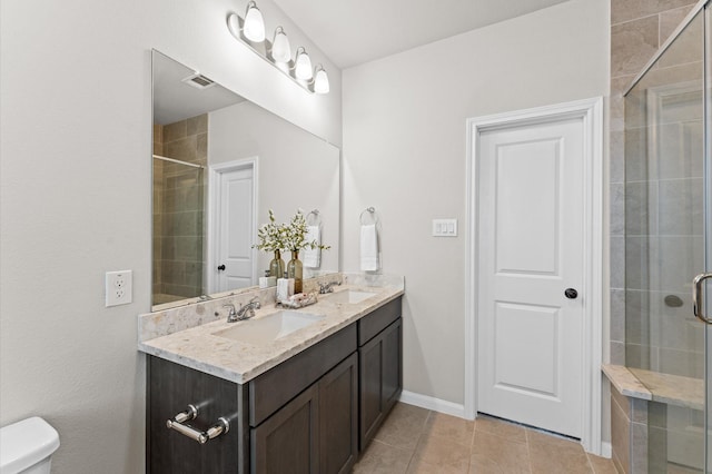 761 Ocean Palms Dr, Katy, TX 77493 - bathroom featuring double vanity, tiled shower, tile patterned floors, toilet, and baseboards