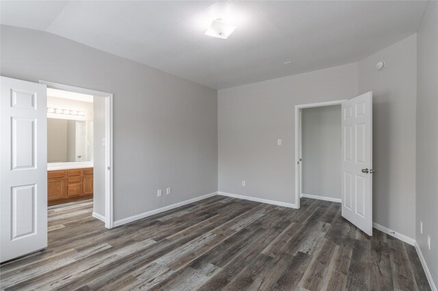 20903 Roxette Ct, Humble, TX 77338 - unfurnished bedroom featuring dark wood finished floors, baseboards, connected bathroom, and vaulted ceiling