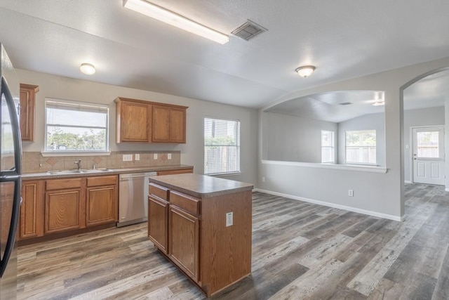 20903 Roxette Ct, Humble, TX 77338 - kitchen with stainless steel appliances, a sink, vaulted ceiling, light wood finished floors, and arched walkways