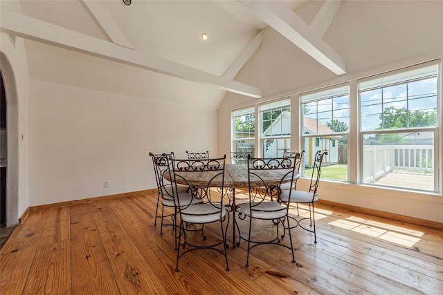 719 Shaver St, Pasadena, TX 77506 - dining area featuring beamed ceiling, light wood-style flooring, arched walkways, and high vaulted ceiling