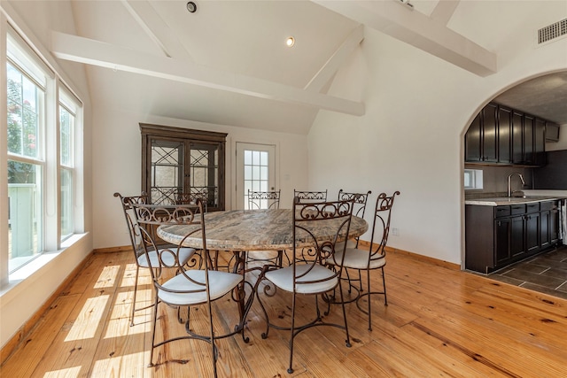 719 Shaver St, Pasadena, TX 77506 - dining room with arched walkways, high vaulted ceiling, beamed ceiling, and light wood-type flooring