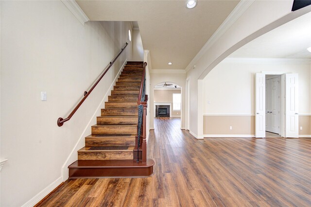 14410 Basalt Ln, Houston, TX 77077 - stairs with wood finished floors, arched walkways, ornamental molding, recessed lighting, and a fireplace