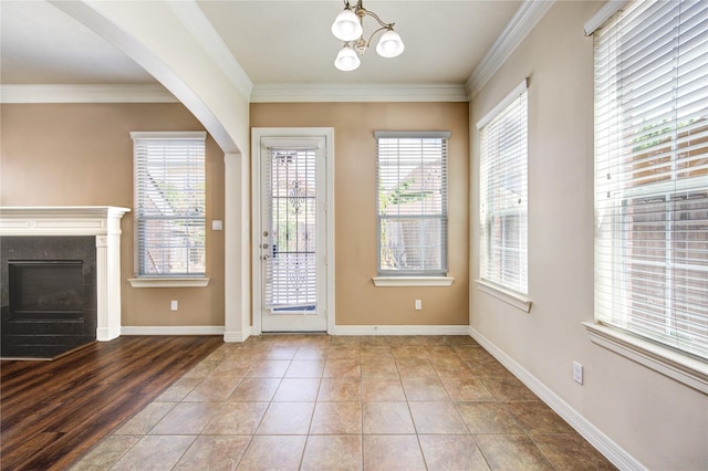 14410 Basalt Ln, Houston, TX 77077 - doorway to outside with plenty of natural light, ornamental molding, a chandelier, a fireplace with flush hearth, and arched walkways