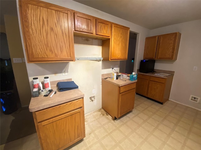 10206 Ravenwood View Ln, Houston, TX 77075 - kitchen featuring light countertops, brown cabinetry, and light floors