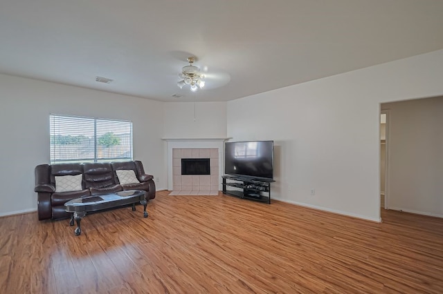 14723 Belterraza Dr, Houston, TX 77083 - living room with ceiling fan, wood finished floors, a tile fireplace, and baseboards