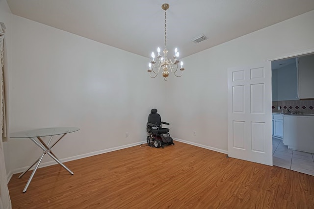 14723 Belterraza Dr, Houston, TX 77083 - unfurnished dining area featuring light wood-type flooring, a chandelier, and baseboards