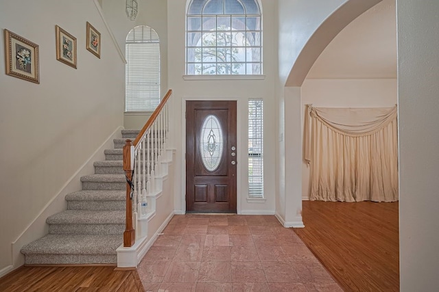 14723 Belterraza Dr, Houston, TX 77083 - entryway featuring arched walkways, plenty of natural light, stairway, baseboards, and a high ceiling