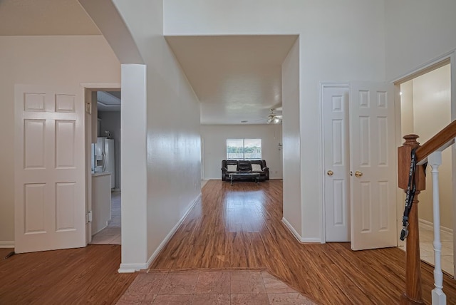 14723 Belterraza Dr, Houston, TX 77083 - corridor featuring wood finished floors, arched walkways, baseboards, and stairs