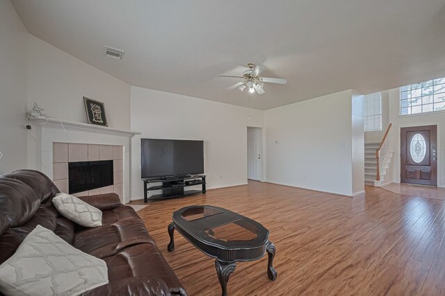 14723 Belterraza Dr, Houston, TX 77083 - living room with a ceiling fan, stairs, light wood-style flooring, and a fireplace