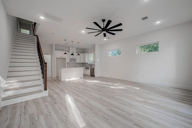 7002 Sidney St, Houston, TX 77021 - unfurnished living room with stairway, light wood finished floors, ceiling fan, baseboards, and recessed lighting