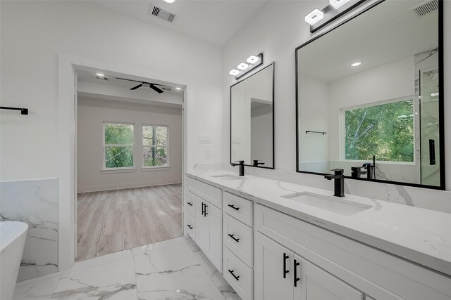 7002 Sidney St, Houston, TX 77021 - full bath with double vanity, a soaking tub, ceiling fan, marble finish floors, and recessed lighting
