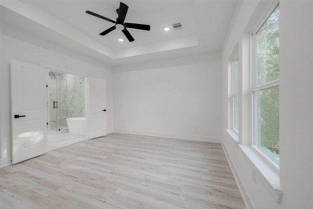 7002 Sidney St, Houston, TX 77021 - unfurnished bedroom featuring a tray ceiling, ensuite bathroom, baseboards, light wood-type flooring, and recessed lighting