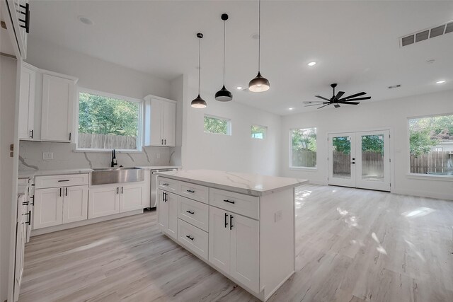 7002 Sidney St, Houston, TX 77021 - kitchen with a sink, light wood-style floors, ceiling fan, stainless steel dishwasher, and white cabinets