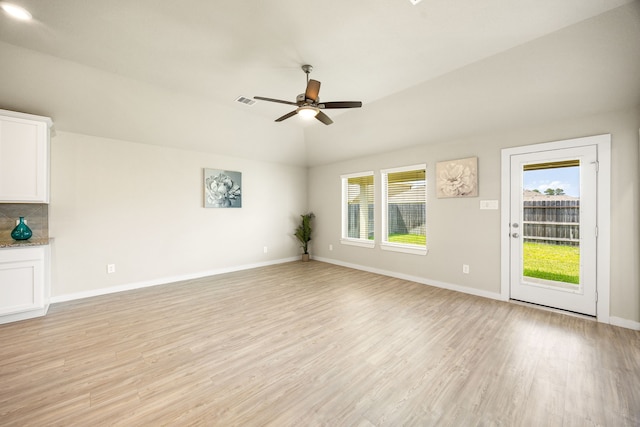 723 Larkspur Shadow Dr, Magnolia, TX 77354 - unfurnished living room featuring plenty of natural light, a ceiling fan, light wood-style flooring, lofted ceiling, and baseboards