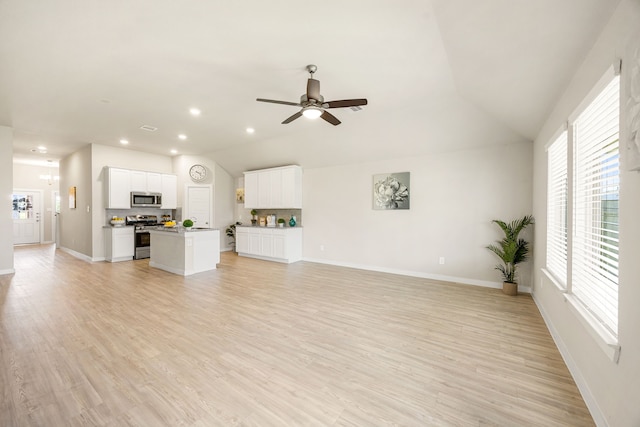 723 Larkspur Shadow Dr, Magnolia, TX 77354 - unfurnished living room with a ceiling fan, vaulted ceiling, light wood-style flooring, recessed lighting, and baseboards