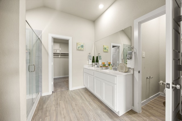 723 Larkspur Shadow Dr, Magnolia, TX 77354 - full bathroom featuring a shower stall, double vanity, wood finished floors, a spacious closet, and baseboards
