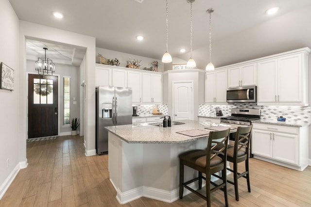 18226 Sofia Willow Way, Cypress, TX 77429 - kitchen with stainless steel appliances, white cabinetry, light wood-style floors, decorative backsplash, and recessed lighting