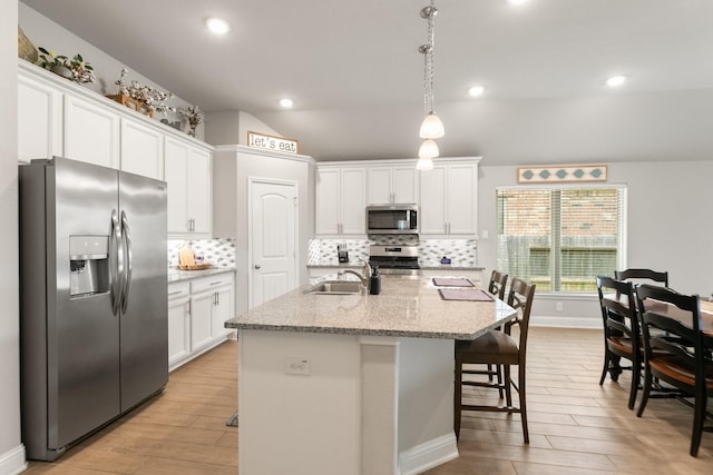 18226 Sofia Willow Way, Cypress, TX 77429 - kitchen featuring appliances with stainless steel finishes, white cabinets, light wood-type flooring, tasteful backsplash, and recessed lighting