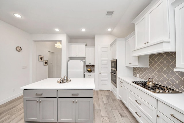 11414 Bush Clover Dr, Cypress, TX 77433 - kitchen featuring appliances with stainless steel finishes, gray cabinets, light countertops, recessed lighting, and light wood-type flooring