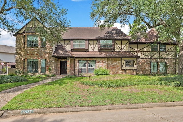 7527 Cart Gate Dr, Houston, TX 77095 - tudor-style house featuring a front yard and brick siding