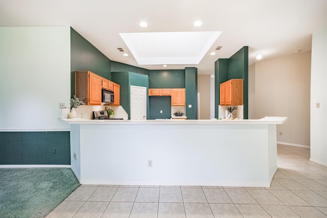 2001 Navajo Dr, Deer Park, TX 77536 - kitchen with black microwave, a tray ceiling, light tile patterned floors, stove, and recessed lighting
