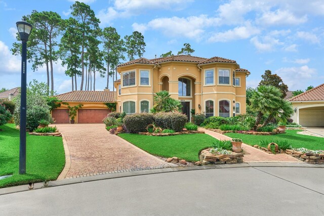 9814 Cape Breeze Dr, Houston, TX 77070 - mediterranean / spanish-style house featuring a tile roof, decorative driveway, stucco siding, and a front yard