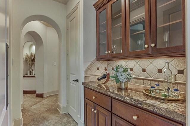 9814 Cape Breeze Dr, Houston, TX 77070 - bar featuring decorative backsplash, arched walkways, and baseboards
