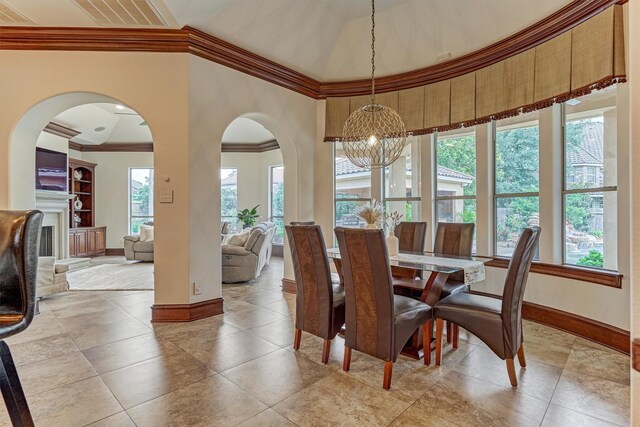 9814 Cape Breeze Dr, Houston, TX 77070 - dining area with a chandelier, baseboards, ornamental molding, arched walkways, and light tile patterned floors