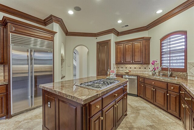 9814 Cape Breeze Dr, Houston, TX 77070 - kitchen with stainless steel appliances, arched walkways, a sink, tasteful backsplash, and ornamental molding