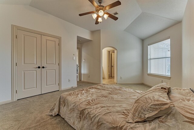 9814 Cape Breeze Dr, Houston, TX 77070 - bedroom with vaulted ceiling, arched walkways, light carpet, a ceiling fan, and a closet