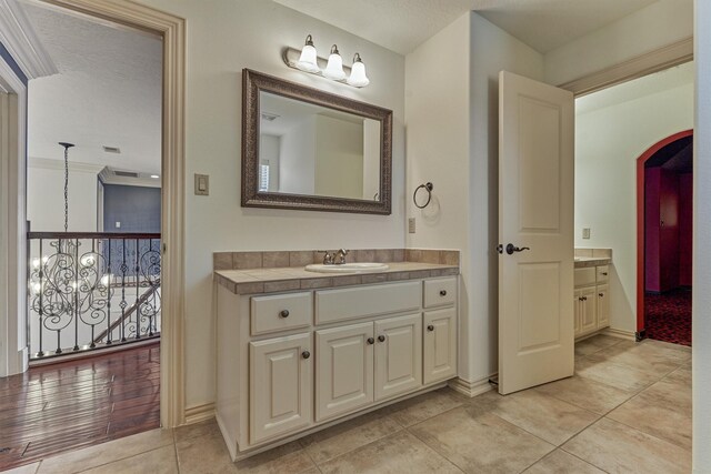 9814 Cape Breeze Dr, Houston, TX 77070 - bathroom with vanity, tile patterned floors, baseboards, and a chandelier