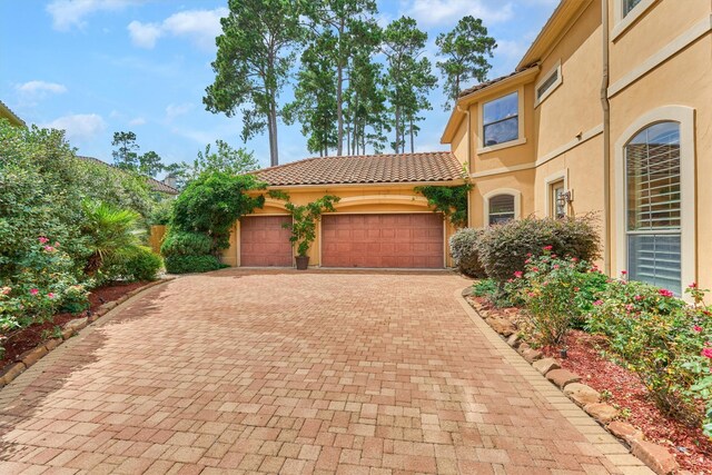 9814 Cape Breeze Dr, Houston, TX 77070 - view of front of house featuring stucco siding, a garage, decorative driveway, and a tiled roof