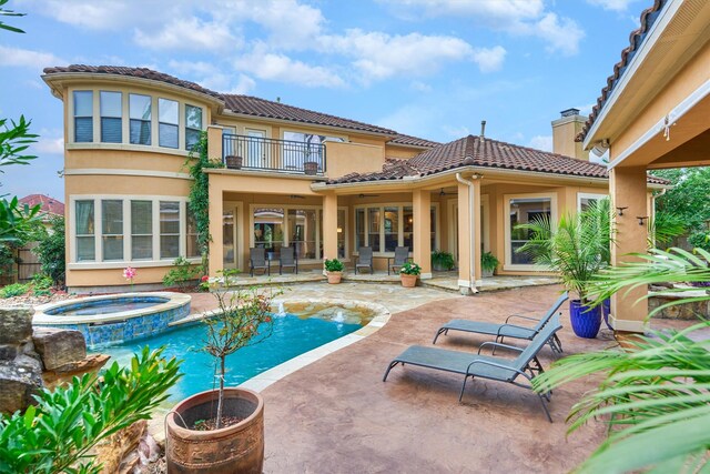 9814 Cape Breeze Dr, Houston, TX 77070 - back of house featuring a balcony, a patio, a tiled roof, stucco siding, and a pool with connected hot tub