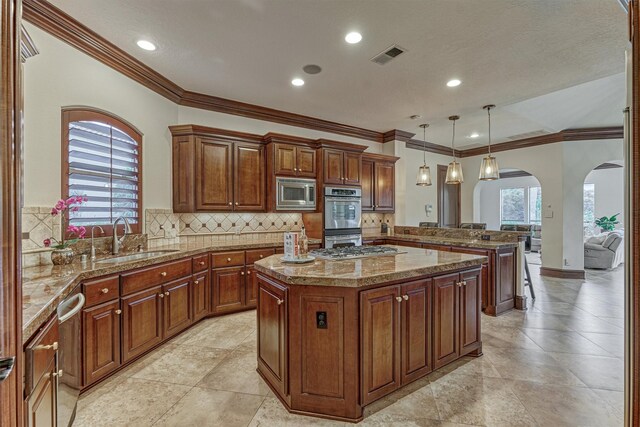 9814 Cape Breeze Dr, Houston, TX 77070 - kitchen featuring stainless steel appliances, a sink, a peninsula, arched walkways, and a center island