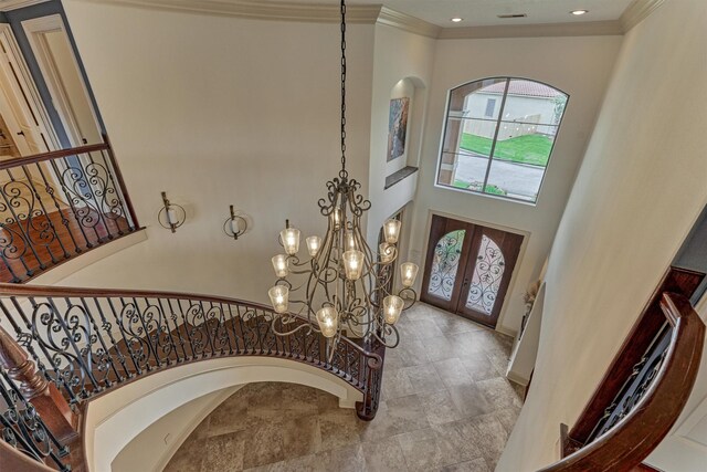 9814 Cape Breeze Dr, Houston, TX 77070 - entrance foyer featuring french doors, stairway, a chandelier, arched walkways, and crown molding