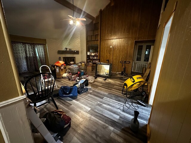 1225 County Road 878b, Sweeny, TX 77480 - interior space featuring ceiling fan, wood finished floors, wooden walls, a brick fireplace, and lofted ceiling