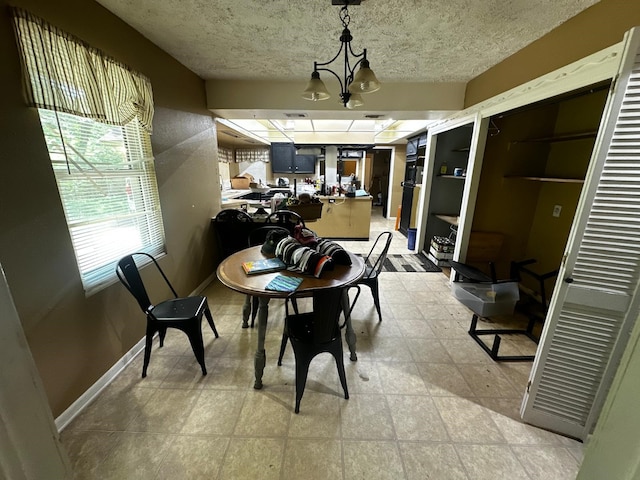 1225 County Road 878b, Sweeny, TX 77480 - dining area with a textured ceiling, baseboards, and a chandelier