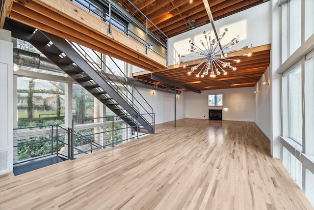 2327 Peckham St, Houston, TX 77019 - unfurnished living room with a chandelier, wood finished floors, stairs, and a towering ceiling