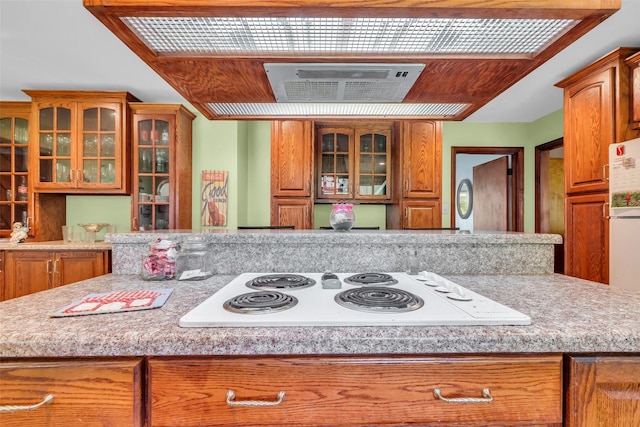 410 Azalea Dr, Baytown, TX 77520 - kitchen featuring white electric stovetop, light countertops, and brown cabinetry