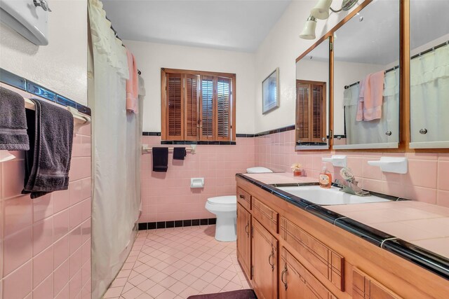410 Azalea Dr, Baytown, TX 77520 - full bathroom with tile patterned floors, vanity, tile walls, and a wainscoted wall