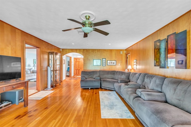 410 Azalea Dr, Baytown, TX 77520 - living area with arched walkways, wood walls, ceiling fan, and light wood finished floors