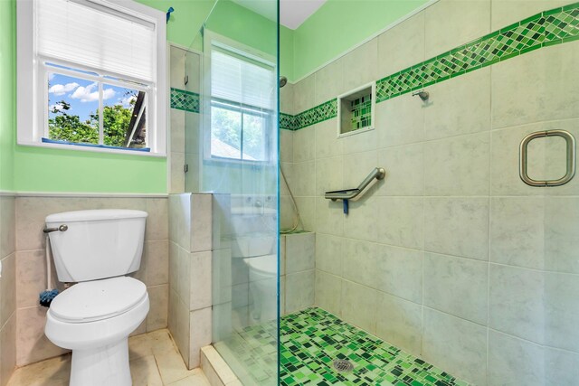 410 Azalea Dr, Baytown, TX 77520 - full bathroom featuring a stall shower, tile walls, tile patterned flooring, and a wainscoted wall
