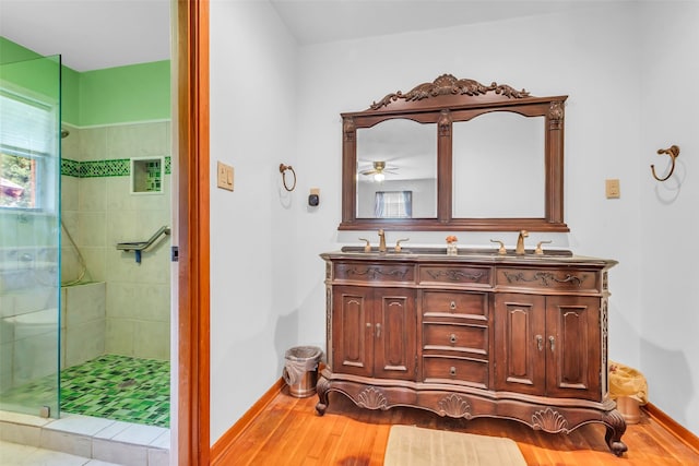 410 Azalea Dr, Baytown, TX 77520 - full bathroom featuring double vanity, tiled shower, wood finished floors, and a ceiling fan