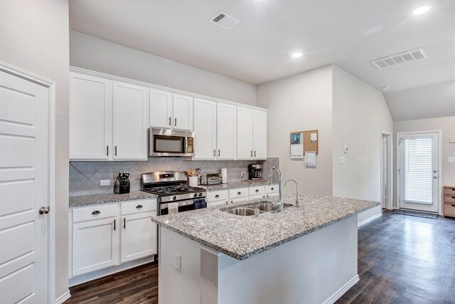 19242 Red Cascade Ct, Tomball, TX 77377 - kitchen with stainless steel appliances, a sink, dark wood-style floors, tasteful backsplash, and an island with sink