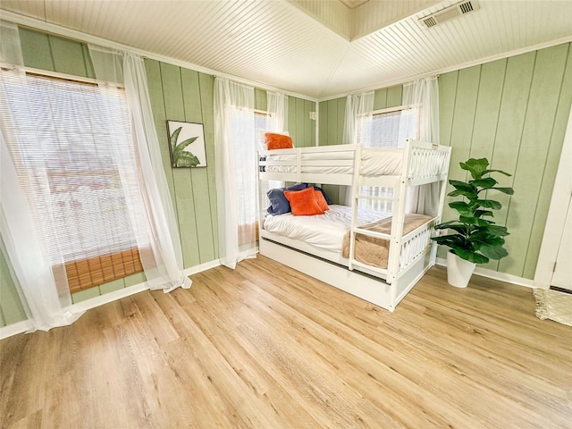1032 N Selwyn Rd, Crystal Beach, TX 77650 - bedroom featuring wood finished floors, wooden walls, and baseboards