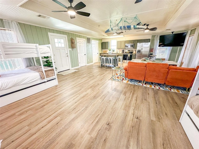 1032 N Selwyn Rd, Crystal Beach, TX 77650 - living room featuring ceiling fan, light wood finished floors, and healthy amount of natural light