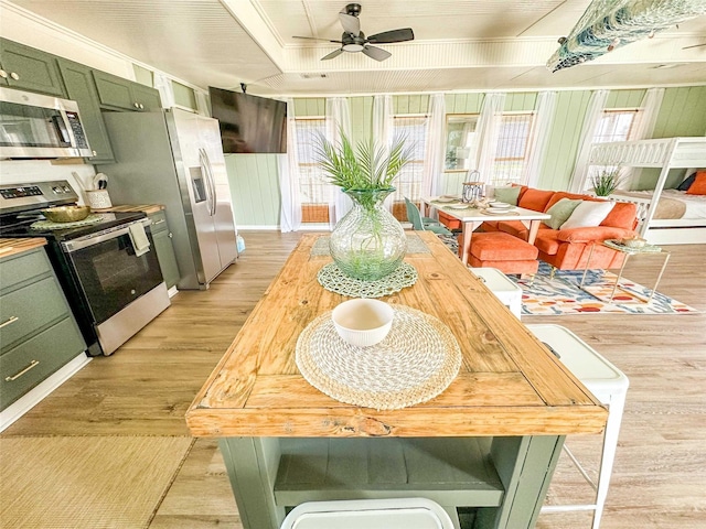 1032 N Selwyn Rd, Crystal Beach, TX 77650 - dining room featuring ceiling fan, light wood-style floors, plenty of natural light, and crown molding