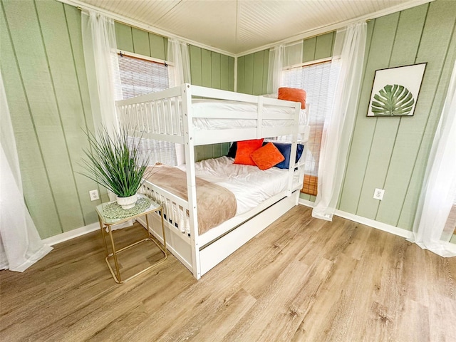 1032 N Selwyn Rd, Crystal Beach, TX 77650 - bedroom featuring wood finished floors, baseboards, and a decorative wall